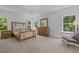 A well-lit main bedroom with a wooden bed frame and dresser, complemented by natural light from two windows at 1338 The Parks Dr, Pittsboro, NC 27312