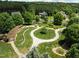 Aerial view of a park with walking paths, green spaces, and a pergola at 1338 The Parks Dr, Pittsboro, NC 27312