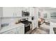 Kitchen showcasing white cabinets, stainless steel appliances, and an open view to living room at 1412 Maple Branch Cir # 35, Graham, NC 27253