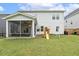 Lush backyard showcasing a play set and screened in porch at 145 Cassada Ct, Holly Springs, NC 27540
