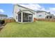 Landscaped backyard with a screened-in porch, play set, and grassy lawn at 145 Cassada Ct, Holly Springs, NC 27540