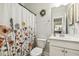 Neutral bathroom featuring a floral shower curtain and a vanity with a sink and mirror at 145 Cassada Ct, Holly Springs, NC 27540