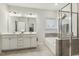 Well-lit bathroom with double vanity, tub, and glass shower for comfort and convenience at 145 Cassada Ct, Holly Springs, NC 27540