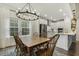 Dining area next to kitchen has a wooden table and chairs beneath a modern chandelier at 145 Cassada Ct, Holly Springs, NC 27540