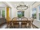 Dining room features a wooden table, chandelier, and views of the outdoor pool and landscaping at 145 Cassada Ct, Holly Springs, NC 27540