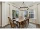 Bright dining area with pool view, featuring a wooden table and stylish chandelier at 145 Cassada Ct, Holly Springs, NC 27540