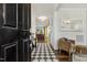 Inviting entryway with a black and white tiled floor, wooden floors, and a view to the living room at 145 Cassada Ct, Holly Springs, NC 27540