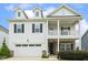 Charming two-story home featuring a welcoming front porch, a two car garage, and manicured landscaping at 145 Cassada Ct, Holly Springs, NC 27540