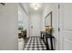 Stylish foyer with a checkered floor, a dark wood bench, and a bright, welcoming atmosphere at 145 Cassada Ct, Holly Springs, NC 27540