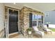 Inviting front porch with stone accents, stylish seating, and a welcoming entrance to the home at 145 Cassada Ct, Holly Springs, NC 27540