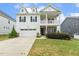 Beautiful two-story home with a two car garage, inviting porch, and lush green lawn at 145 Cassada Ct, Holly Springs, NC 27540