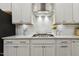 Detailed shot of the kitchen cooktop, vent, and cabinet at 145 Cassada Ct, Holly Springs, NC 27540