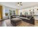 Open-concept living area with large sectional sofa and bright windows, flowing into the kitchen at 145 Cassada Ct, Holly Springs, NC 27540