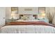 Comfortable bed with coordinated pillows and blankets, framed by bedside lamps and minimalist artwork at 145 Cassada Ct, Holly Springs, NC 27540