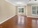 Living room featuring gleaming hardwood floors, large windows, and ample space at 1517 Chestnut Falls Rd, Wendell, NC 27591