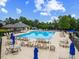 Large community pool with lounge chairs, umbrellas, and covered seating areas at 1704 Fawn Chase Ct, Wake Forest, NC 27587