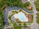Aerial shot of a large community pool, chairs, tables, umbrellas, and a nearby parking lot at 1704 Fawn Chase Ct, Wake Forest, NC 27587