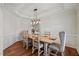 Elegant dining room featuring modern lighting, decorative trim, and a tray ceiling at 1704 Fawn Chase Ct, Wake Forest, NC 27587