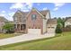 Charming brick home with a three car garage, well-kept lawn, and inviting curb appeal at 1704 Fawn Chase Ct, Wake Forest, NC 27587