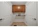 Functional laundry room offers tile flooring, overhead cabinets, and drying rack at 1704 Fawn Chase Ct, Wake Forest, NC 27587