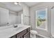 Bright bathroom featuring a marble vanity, toilet, shower, tub, and window at 173 Forsyth Pkwy Pkwy, Clayton, NC 27520