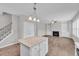 Spacious kitchen island with stainless steel appliances and an open view of the living room fireplace at 173 Forsyth Pkwy Pkwy, Clayton, NC 27520