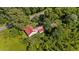 Aerial view of a charming home with a durable red metal roof surrounded by lush greenery at 1908 Rocky Cross Rd, Zebulon, NC 27597