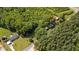 Aerial view of a charming home with a durable red metal roof surrounded by lush greenery at 1908 Rocky Cross Rd, Zebulon, NC 27597