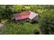 Aerial view of a charming home with a durable red metal roof surrounded by lush greenery at 1908 Rocky Cross Rd, Zebulon, NC 27597
