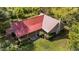 Aerial view of a charming home with a durable red metal roof surrounded by lush greenery at 1908 Rocky Cross Rd, Zebulon, NC 27597