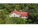 A beautiful home with a red roof is surrounded by a vibrant green landscape and mature trees at 1908 Rocky Cross Rd, Zebulon, NC 27597