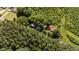Aerial view of a charming home with a durable red metal roof surrounded by lush greenery at 1908 Rocky Cross Rd, Zebulon, NC 27597