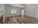 Bright bedroom featuring wood floors, white trim, large windows, and a ceiling fan for added comfort at 1908 Rocky Cross Rd, Zebulon, NC 27597