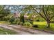 Charming home with a lush front yard, enveloped by mature trees, and a lengthy driveway at 1908 Rocky Cross Rd, Zebulon, NC 27597