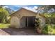 Exterior view of a detached garage with a large door and adjacent greenery at 1908 Rocky Cross Rd, Zebulon, NC 27597