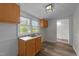 Bright laundry room featuring laminate floors, sink, white walls, and cabinets at 1908 Rocky Cross Rd, Zebulon, NC 27597