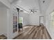 Living room featuring a decorative fireplace, wood floors, ceiling fan, and bright windows at 1908 Rocky Cross Rd, Zebulon, NC 27597