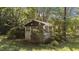 Small outdoor structure surrounded by dense shrubbery and trees at 1908 Rocky Cross Rd, Zebulon, NC 27597