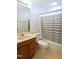 Bathroom with a toilet, vanity, shower, and tub with gray and white shower curtain at 2006 N Ashland Dr, Burlington, NC 27217