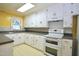 Eat-in kitchen features white cabinets and appliances and grey countertops at 2006 N Ashland Dr, Burlington, NC 27217