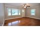 Bright living room with hardwood floors, a ceiling fan, and abundant natural light from large windows at 2006 N Ashland Dr, Burlington, NC 27217
