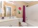 Well-lit bathroom features a tub, shower, and a vanity with storage space at 227 Kenmont Dr, Holly Springs, NC 27540
