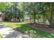 Well-maintained common area with lush lawn and mature trees, perfect for community enjoyment at 227 Kenmont Dr, Holly Springs, NC 27540