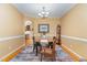 Bright dining room with modern lighting, a round table, and hardwood flooring at 227 Kenmont Dr, Holly Springs, NC 27540