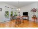 Sunlit dining area with hardwood floors, stylish lighting, and easy access to the balcony through glass doors at 227 Kenmont Dr, Holly Springs, NC 27540