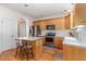 Updated kitchen with wood cabinets, stainless steel appliances, granite countertops, and a center island with seating at 227 Kenmont Dr, Holly Springs, NC 27540