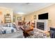 Inviting living room featuring a cozy fireplace, hardwood floors, and an open layout to the dining area at 227 Kenmont Dr, Holly Springs, NC 27540