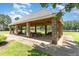 Community pavilion featuring stone columns, picnic tables, and a serene view of the lake at 227 Kenmont Dr, Holly Springs, NC 27540