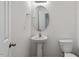 Cozy powder room with pedestal sink, oval mirror, and white toilet at 228 Botanical Ct, Bunnlevel, NC 28323