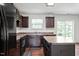 Well-equipped kitchen featuring dark wood cabinets, a center island, and black appliances at 228 Botanical Ct, Bunnlevel, NC 28323